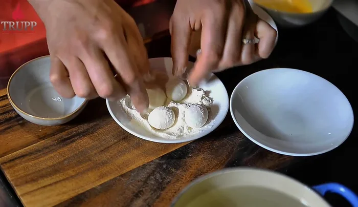 Roll the peeled eggs in flour.