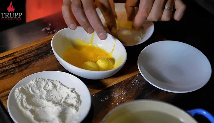 Dip the floured eggs in an egg wash (whisked egg only, no milk).