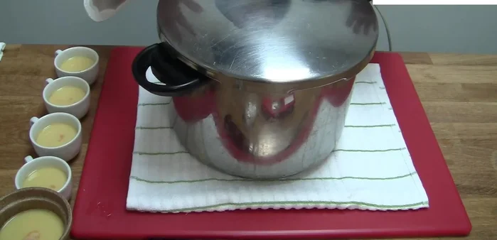 Steam the chawanmushi. For optimal results, ensure the steamer is producing full steam. Cover the back of the lid with a towel to prevent condensation from dripping onto the custard. Start with high heat (2-3 minutes), then reduce to medium-low heat and steam for an additional 13 minutes (approximately 50 minutes total).
