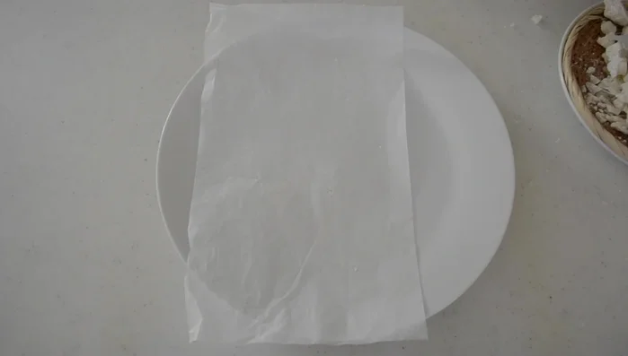 Smash dried mochi into small, bite-sized pieces. Press them onto parchment paper, leaving space between each piece.