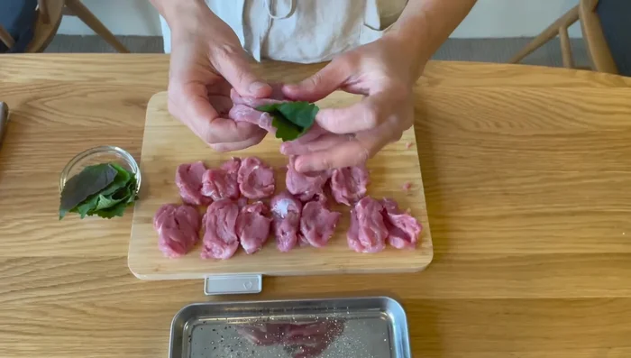 Place a shiso leaf between two pork slices to create a sandwich.