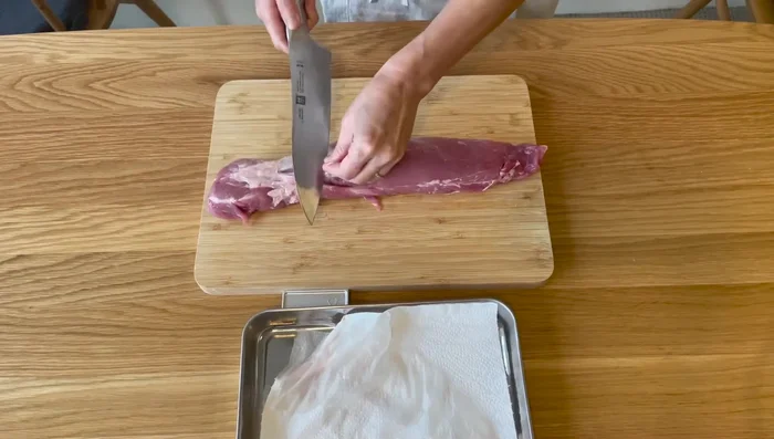 Trim the pork fillet and knead it.