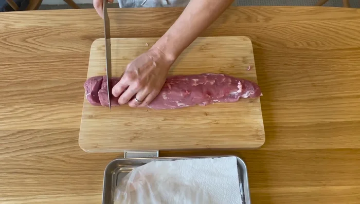 Cut the pork fillet into 1.5-2 cm thick slices, then cut each slice in half.