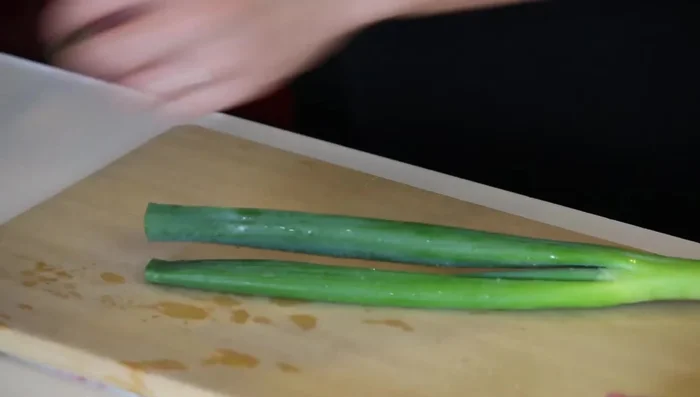Prepare Japanese leek: Cut off the dried top and thinly slice. (144.319)
