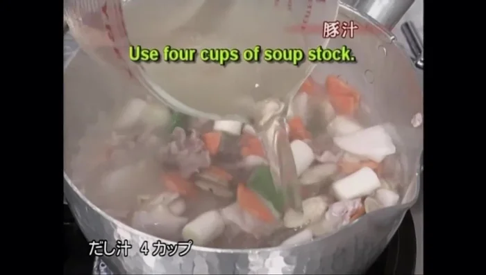 Pour in 4 cups of dashi stock. Once it simmers, add 1 cup more.