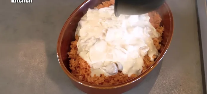Pour the white sauce over the ketchup rice. Top with cheese.