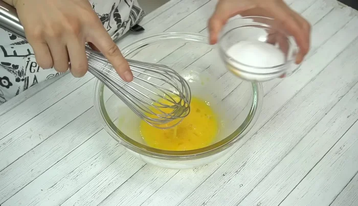 Lightly beat eggs, then quickly whisk in granulated sugar to prevent clumping.