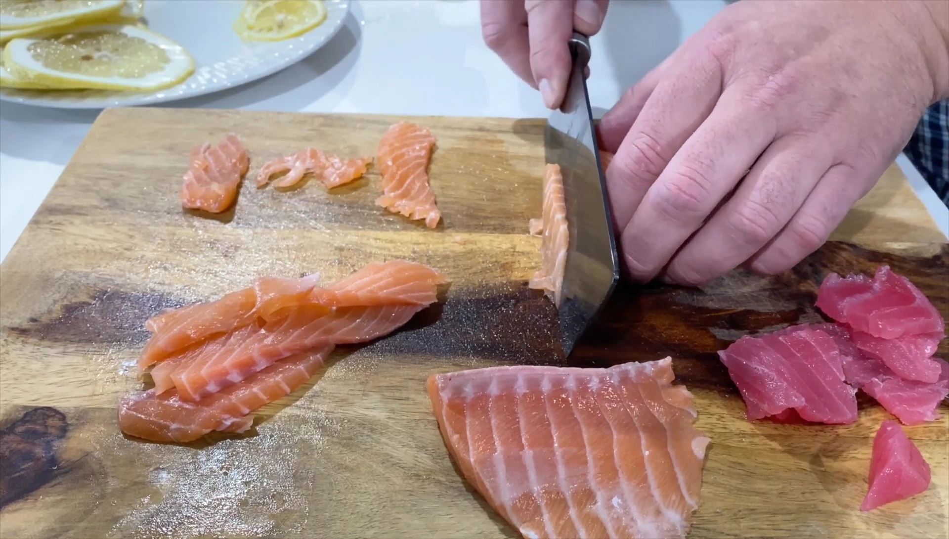 The chef discusses the differing methods for slicing salmon and tuna.