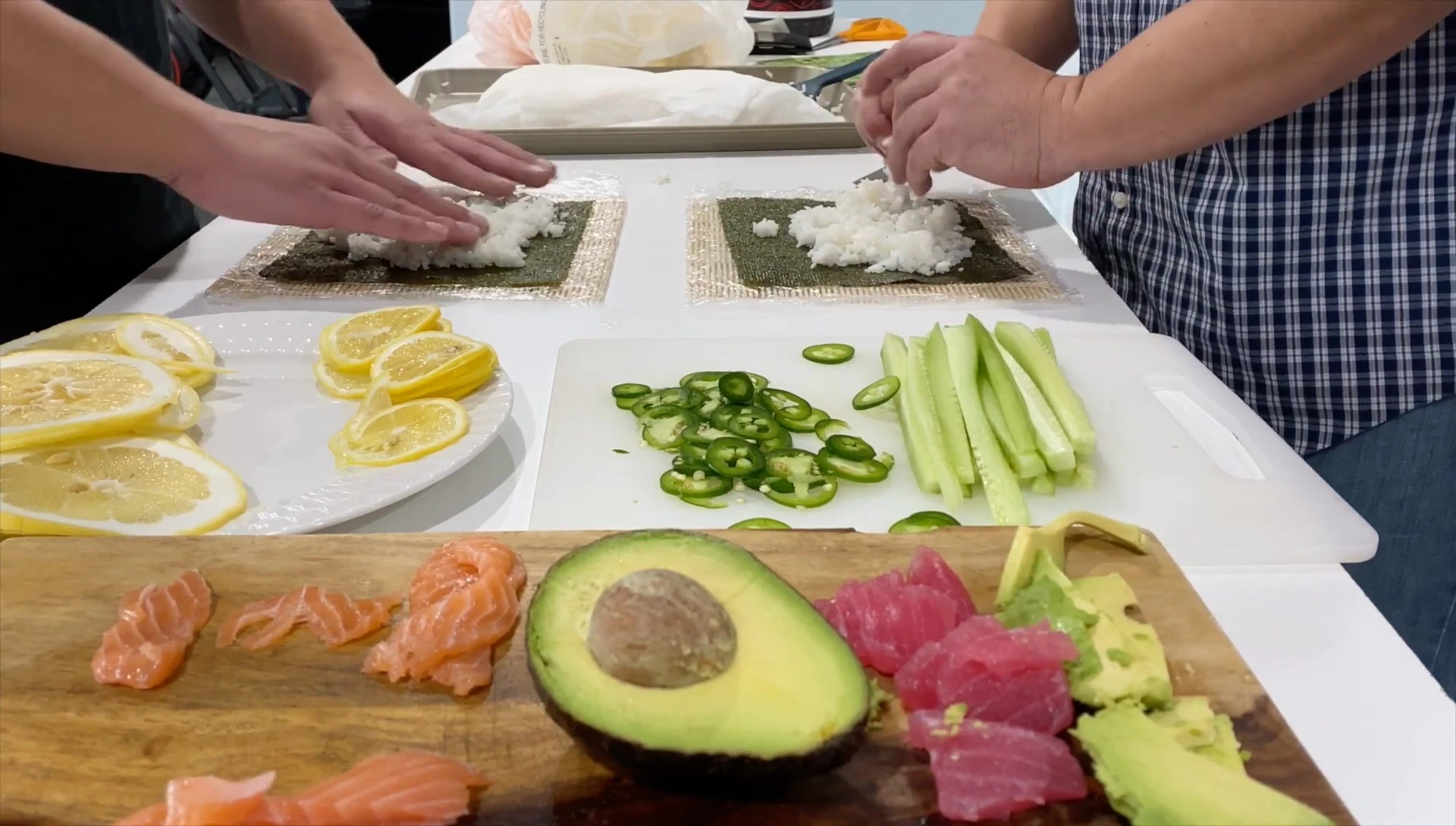 The chef uses their fingers to roll the sushi.