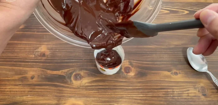Add the raw chocolate mixture to the cups, ensuring it's not overflowing.