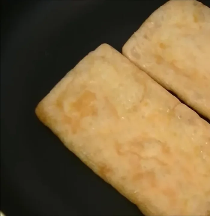 Place two aburaage tofu pockets in the pan. You can use a little sunflower oil if desired.