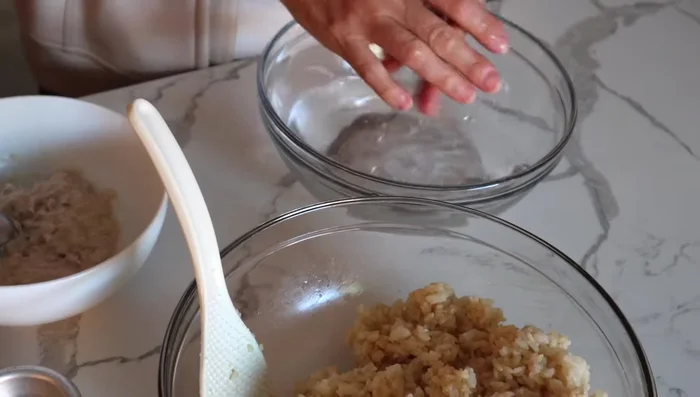 Wet your hands with water. Take about 3/4 cup of rice, press it into a round shape, and make a well in the center.