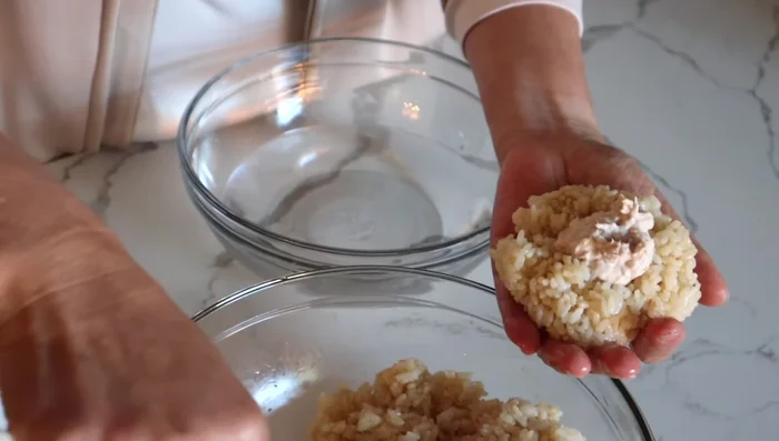 Close the well with another 1/4 cup of rice and reshape. If it's difficult to shape by hand, use plastic wrap to prevent the rice from falling apart.