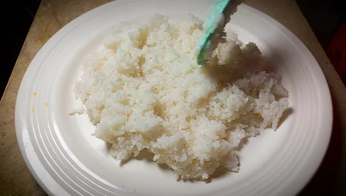 Spread the cooked rice on a large tray to cool to room temperature. Add 1/2 teaspoon each of sugar and salt, and 1 tablespoon of white vinegar. Mix well.