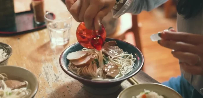 Assemble the dish: Combine the cooked noodles, broth, and pork. Add toppings like pickled ginger and local rice. (214.319)