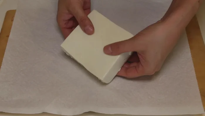 Drain the tofu very well. Remove it from the package and wrap it tightly in paper towels. Microwave at 600 watts for two minutes per tofu block.