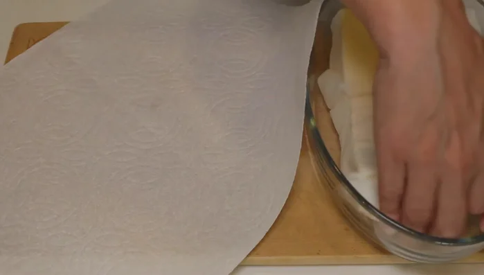 Wrap the microwaved tofu in fresh paper towels. Place a heavy object on top and let it sit for 10 minutes to press out excess water.