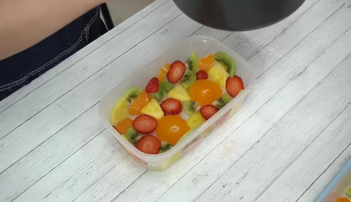 Remove from heat. Quickly pour the milk mixture into the chilled Tupperware container, ensuring the fruit is submerged.