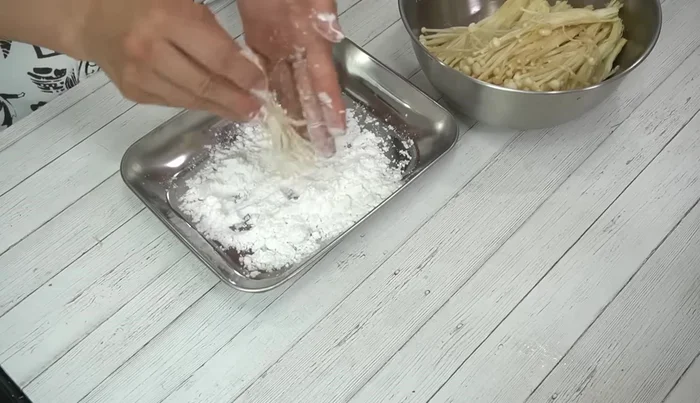 Coat the enoki mushrooms with potato starch, shaking off any excess.