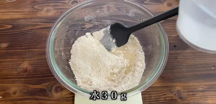 Add water and mix until a uniform, slightly sticky dough forms.