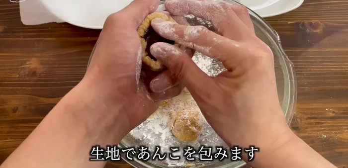 Take one portion of dough, flatten it, and place a portion of bean paste in the center. Wrap the dough around the bean paste, pinching the edges to seal. Repeat with the remaining dough.