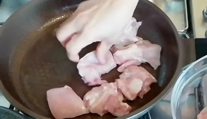 Fry the chicken thighs until lightly browned. (Note: If using a non-stick pan, you may not need to add oil.)