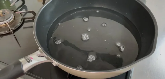 Add water to a frying pan and bring it to a boil.