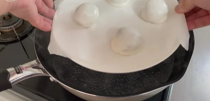 Place a plate in the frying pan for height adjustment, place the manju on top, cover, and steam over medium heat for 10 minutes.