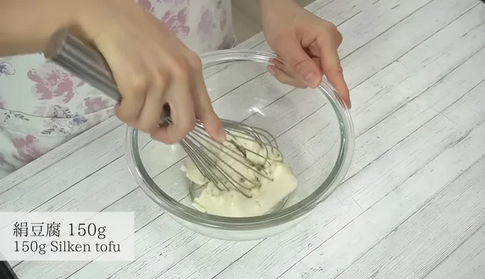 Mash silken tofu in a bowl until smooth using a whisk.