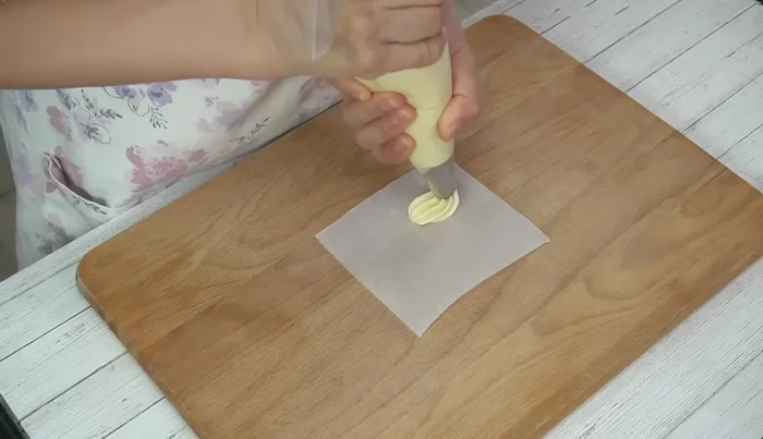 Pipe the batter onto 10cm x 10cm squares of parchment paper, leaving space in the center for expansion.