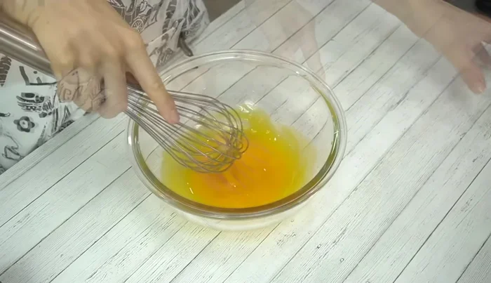 Beat egg yolks until slightly pale. Add salad oil (or rice oil) and mix lightly until fluffy.