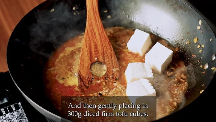 Add chicken broth and diced firm tofu. Bring to a boil, then reduce heat to simmer.