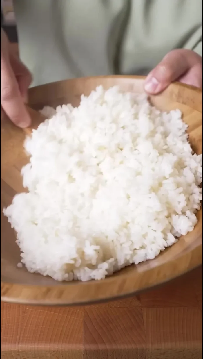 Mix the warm rice with the sushi vinegar. Adding sesame seeds is optional but recommended.