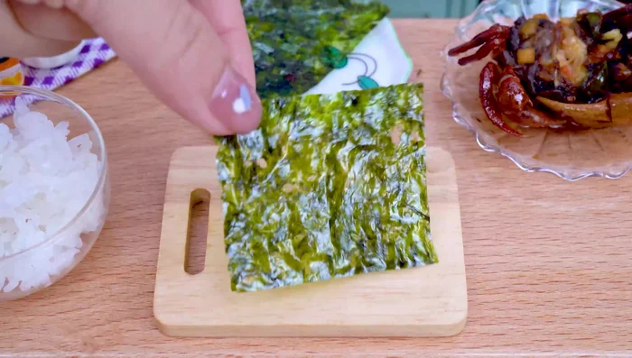 Prepare the crab sushi: Put crab meat on seaweed, top with egg yolk and sesame seeds.
