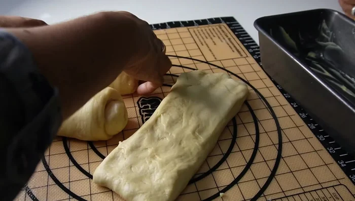 Assemble in loaf pan: Place the three dough logs into the loaf pan, seam-side down, and gently press them together.
