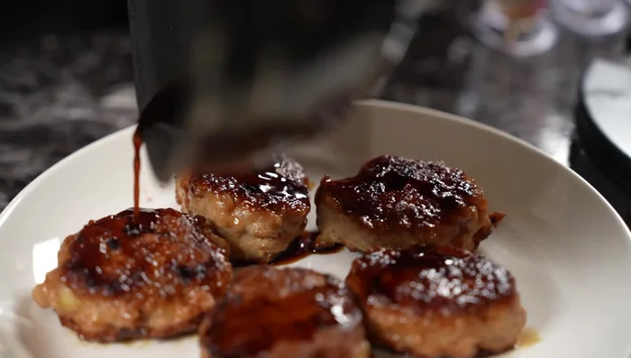 Plate the Tsukune, drizzle with remaining sauce, garnish with egg yolk and perilla leaves (optional).