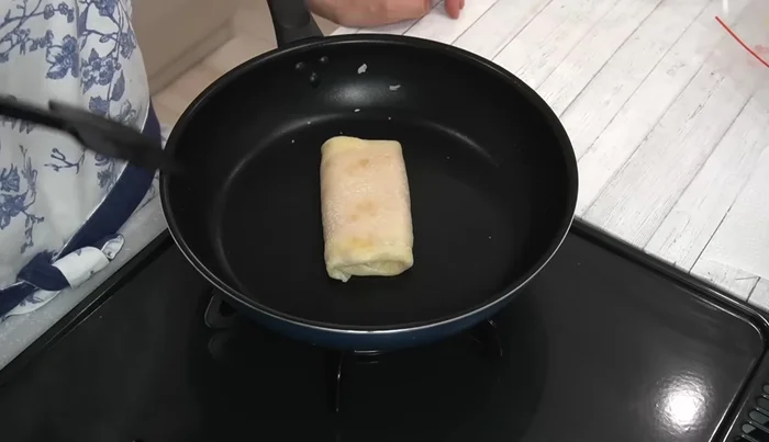 Brown the burrito: Place the rolled burrito seam-down in the pan and cook over medium heat until nicely browned on all sides, ensuring the cheese melts completely.