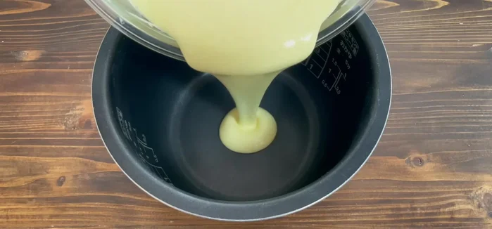 Pour the batter into the prepared rice cooker. Tap gently to remove air bubbles.