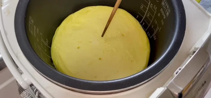 Once cooked, place parchment paper on a plate, invert the rice cooker onto the plate to release the cheesecake.