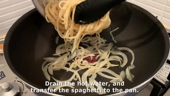 Cook pasta: Cook spaghetti, drain, and add to the pan with sautéed onions, cooked salmon, seasonings (bouillon, soy sauce, sugar), and butter.