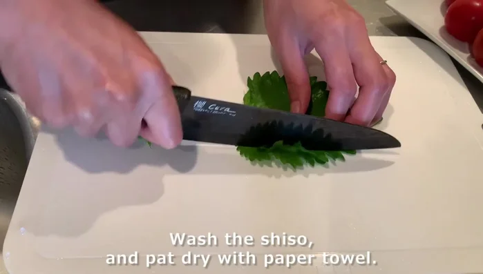 Prepare shiso tomato salad: Wash and finely slice shiso. Dice tomatoes.
