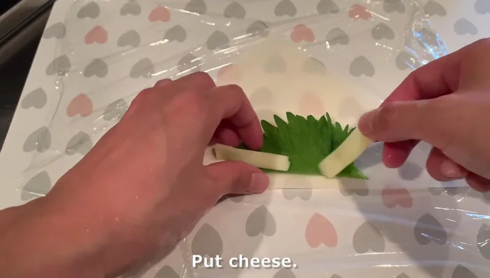 Assemble spring rolls: Place ½ shiso leaf, cheese, and bacon on a spring roll skin half. Roll, securing the ends.