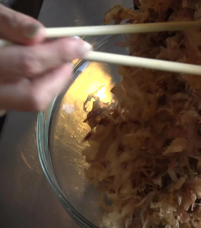 Transfer katsuobushi to a bowl, let cool, and crush into small pieces by hand. (68.69)