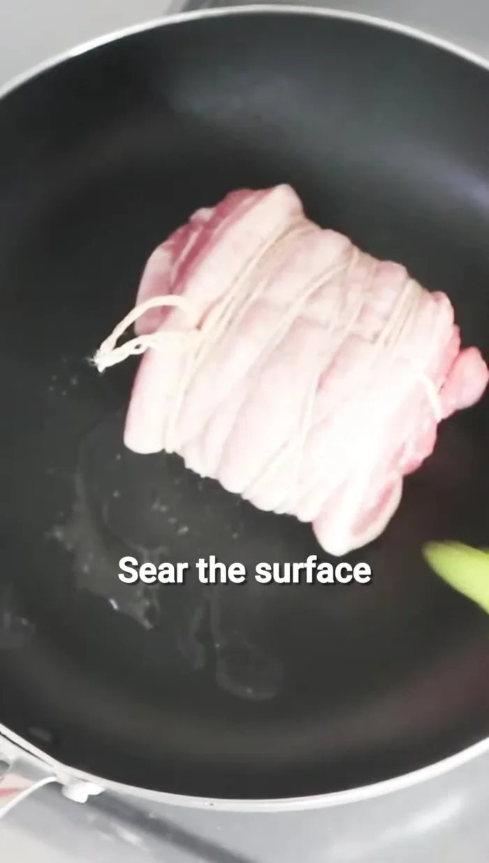 Sear the pork belly until golden brown.