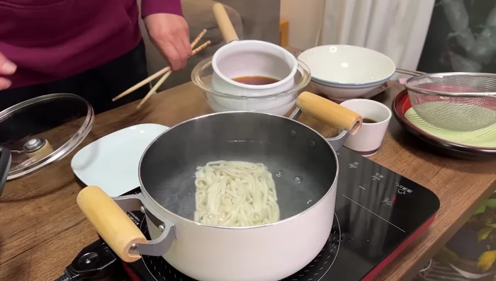 Cook frozen udon noodles. Rinse with cold water and chill. Pour the chilled sauce over the noodles and add your favorite toppings.