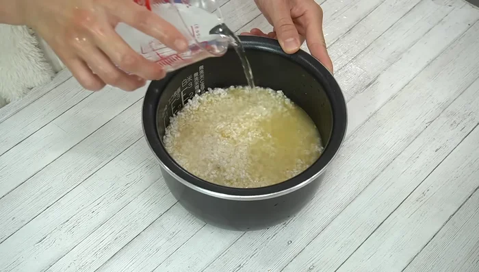 Add water to just below the second mark on the rice cooker. [395.8]