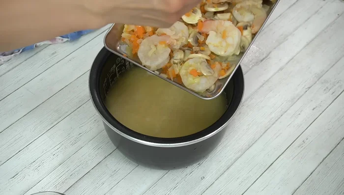 Add the stir-fried shrimp and vegetables to the rice cooker. Mix well. [408.16]