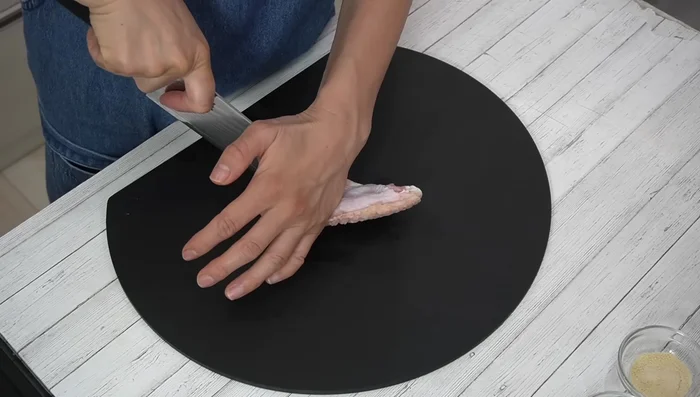 Cut between the bones of the chicken wing parts you'll use for the tangled chicken to make it easier to eat and improve flavor absorption.