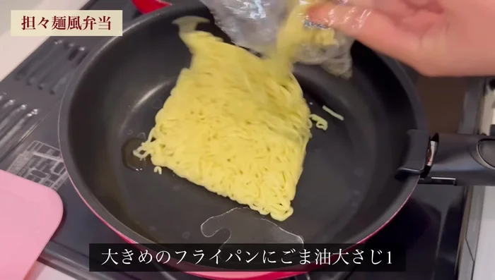 In a large frying pan, add 1 tablespoon sesame oil, 5 sheets of yakisoba noodles, break them up and stir-fry for 3 minutes. Add a spoonful of water and a teaspoon of chicken stock; mix well.