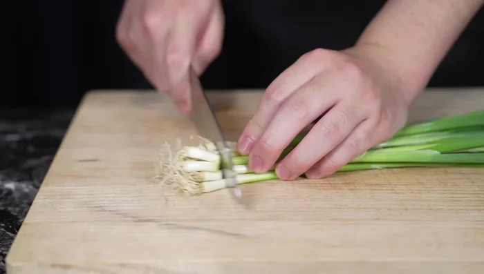 Trim the root ends and tips of the chives, then fold each chive in half, mark the middle, and cut it in half.